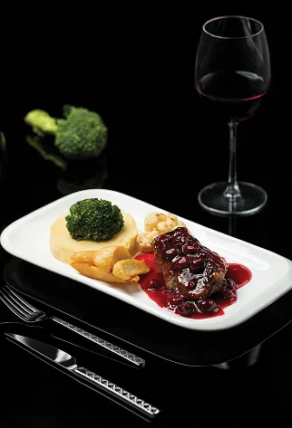 Plat de viande avec sauce aux fruits rouges, pur&eacute;e, brocoli, verre de vin rouge.